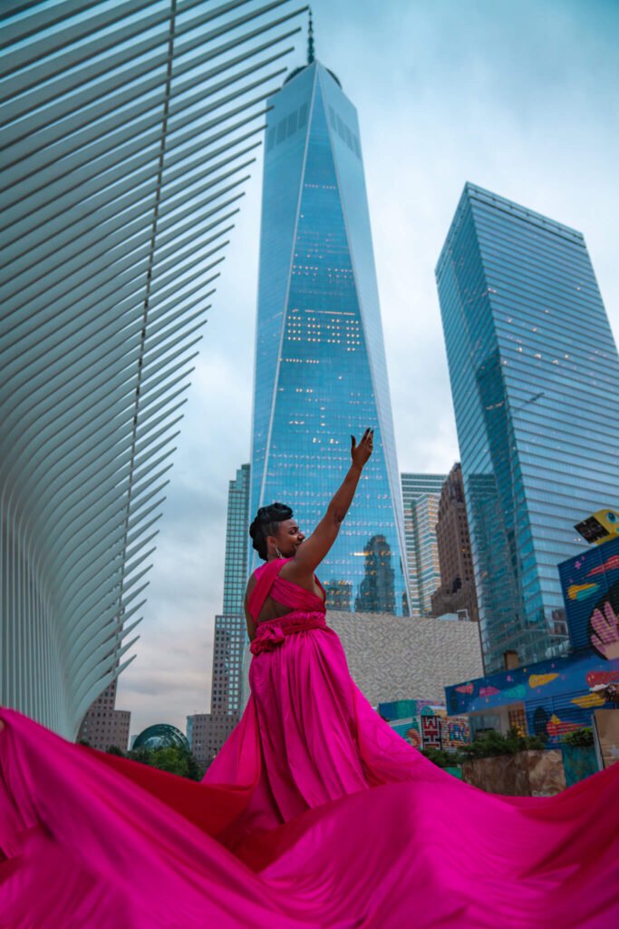 girl in a hot pink dress doing a flying dress photoshoot at the Freedom tower in Manhattan