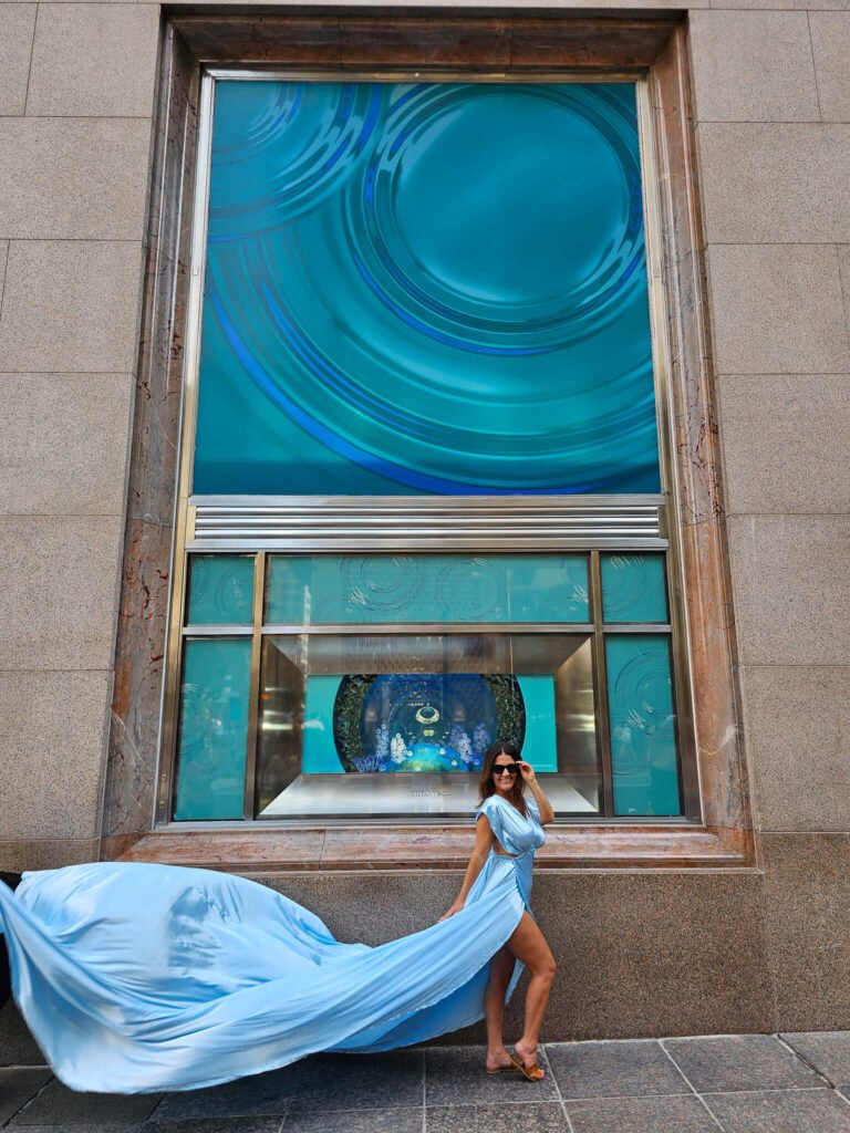 girl in a light blue flying dress in front of Tiffany's NYC